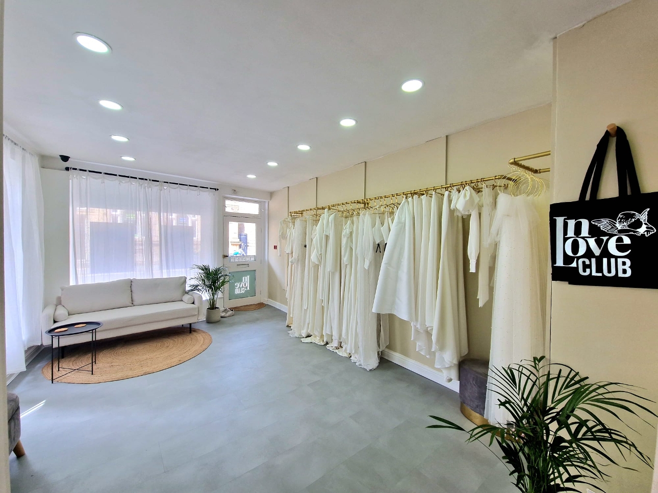 white sofa in wedding shop blue carpet dresses on rails