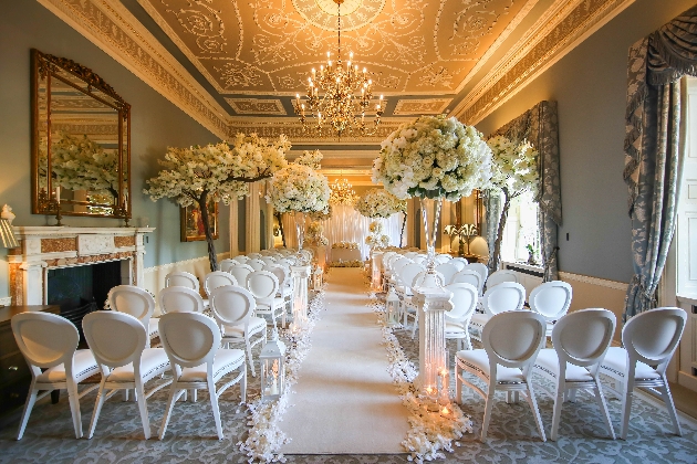 ceremony room with white chairs, chandelier, blossom trees