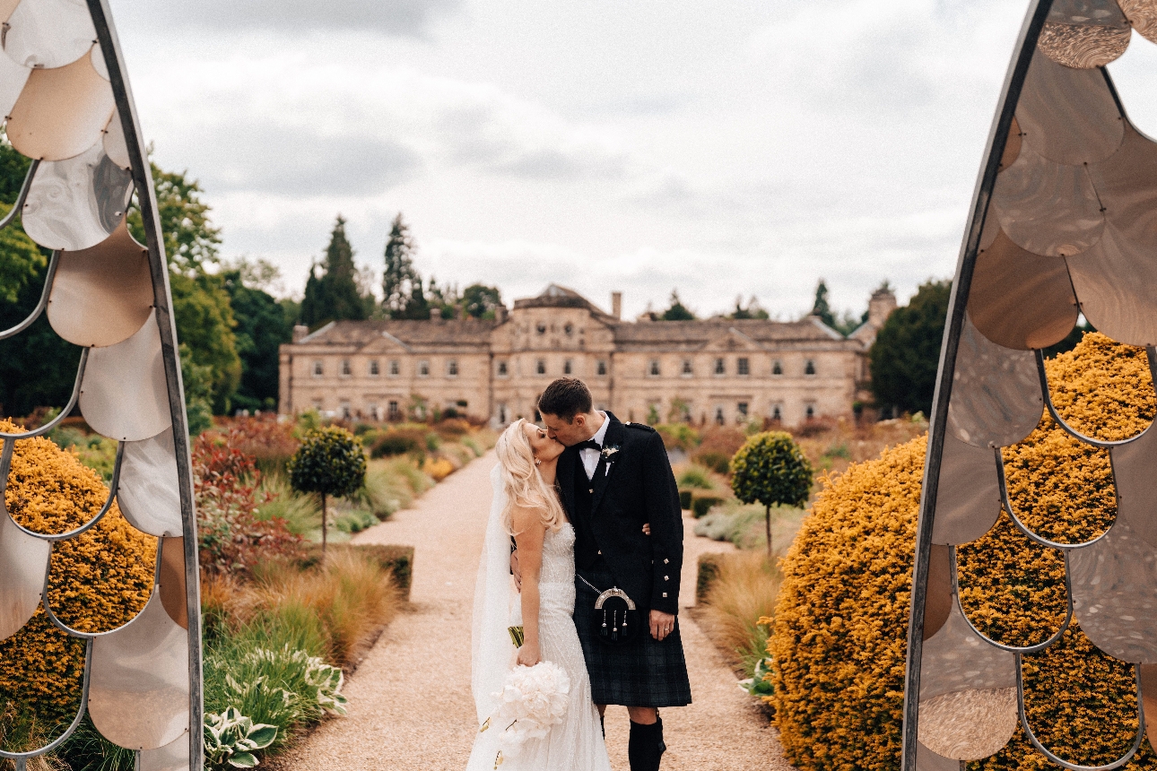 couple stood outside cloudy day house in background 