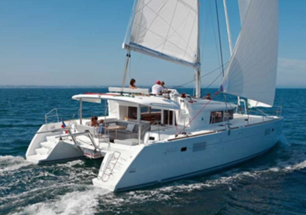 The back of a white boat sailing in the ocean with people on board