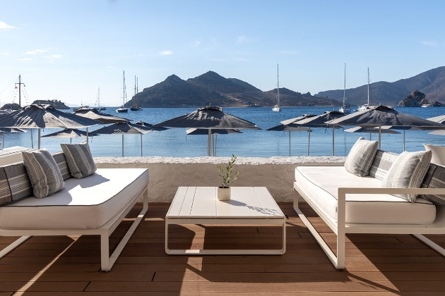 Two white sofas on a terrace overlooking the sea