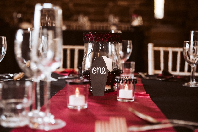 red and black centrepiece with coffin-shaped table numbers and battery tea lights in holders