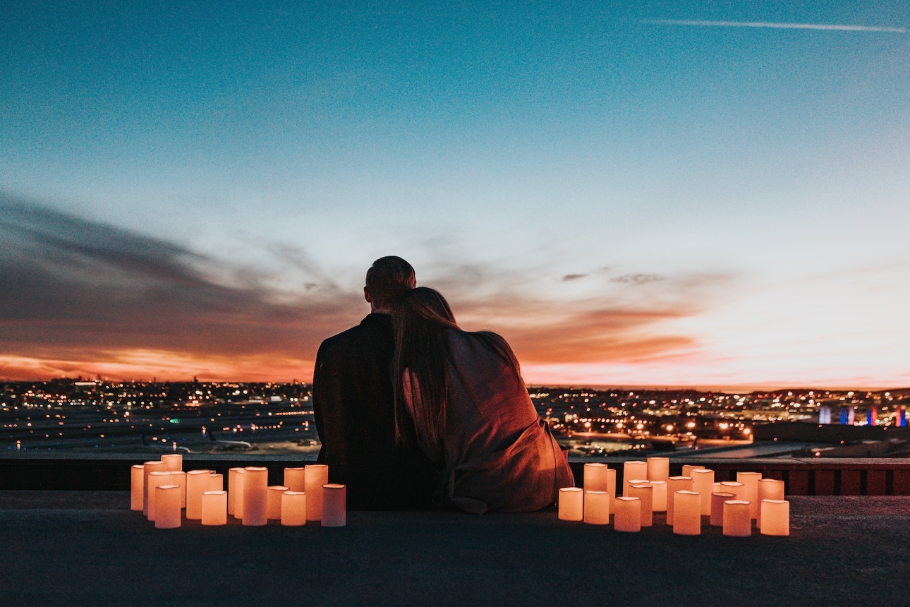 couple on roof at sunset with candles around 