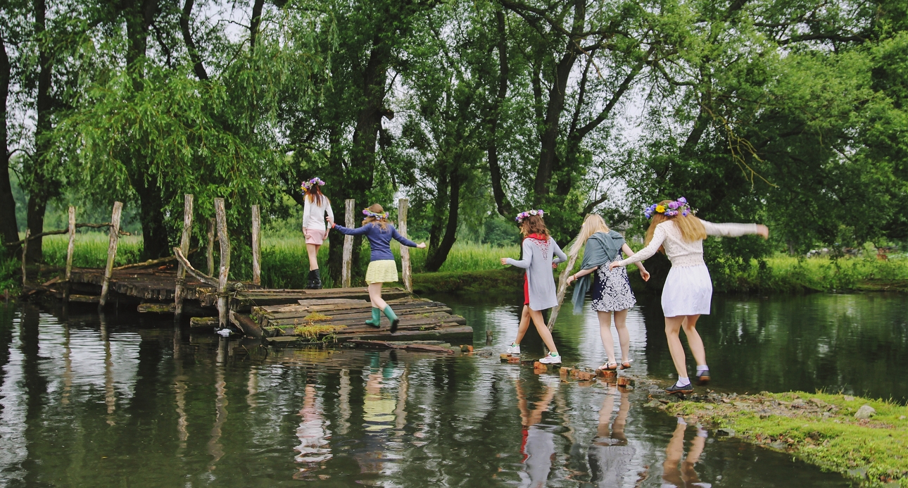 group of women walking along a river in the countryside