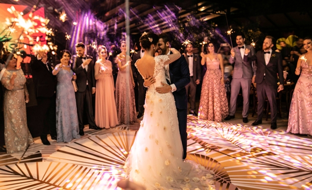 couple having first dance outside surrounded by wedding guests