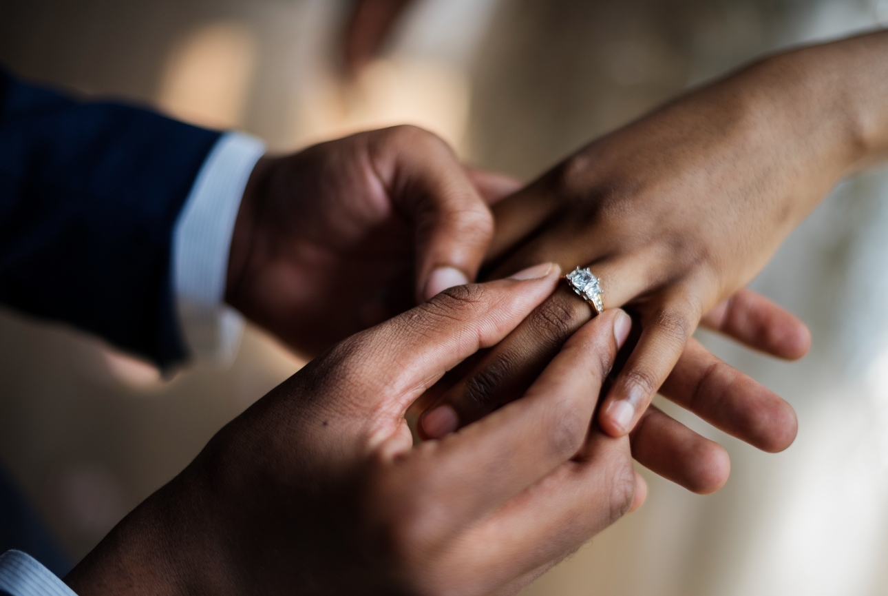 hand putting ring on another person's hand