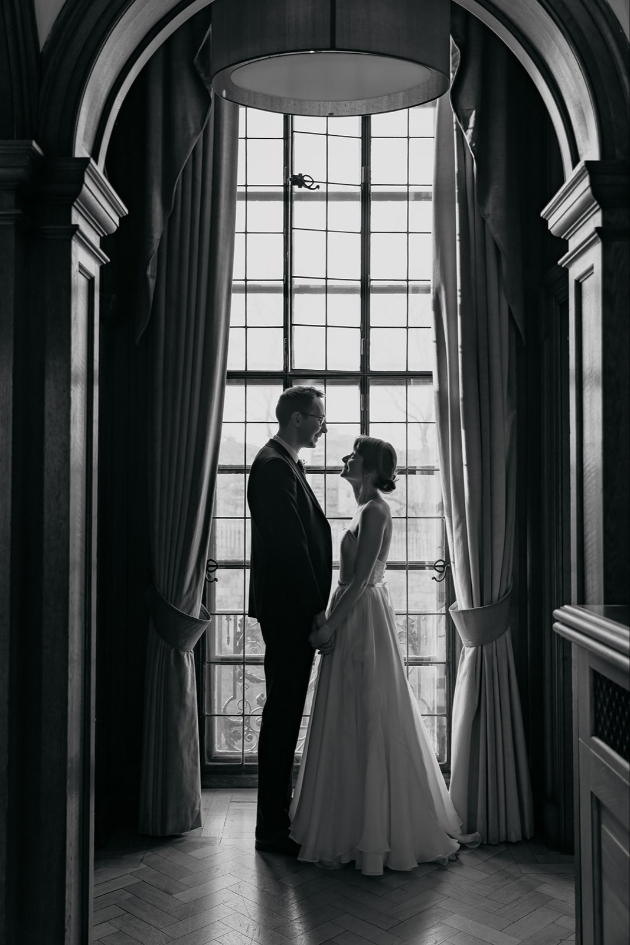 black and white image of bride and groom in front of tall window at The Grand in York 