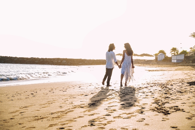 couple walking hand in hand along a beach
