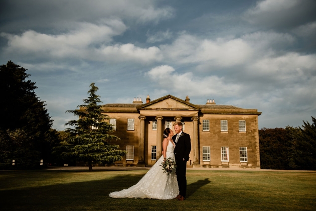Bride and groom on the lawn in front of Rise Hall
