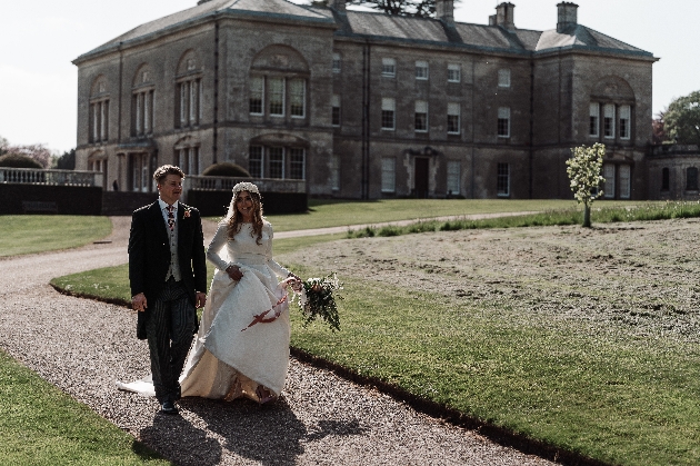 Bride and groom walking away from Sledmere House