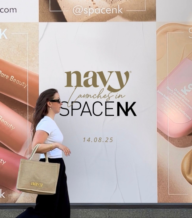 woman walking in front of a sign that says Navy is launching in SpaceNK Aug25