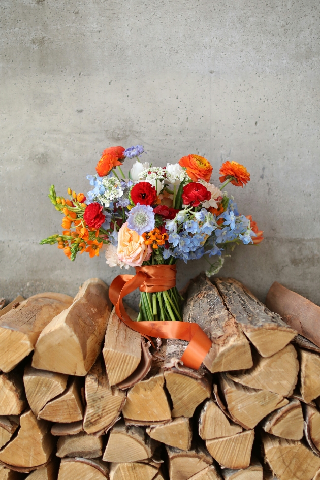 wildflower bouquet sat on wood pile