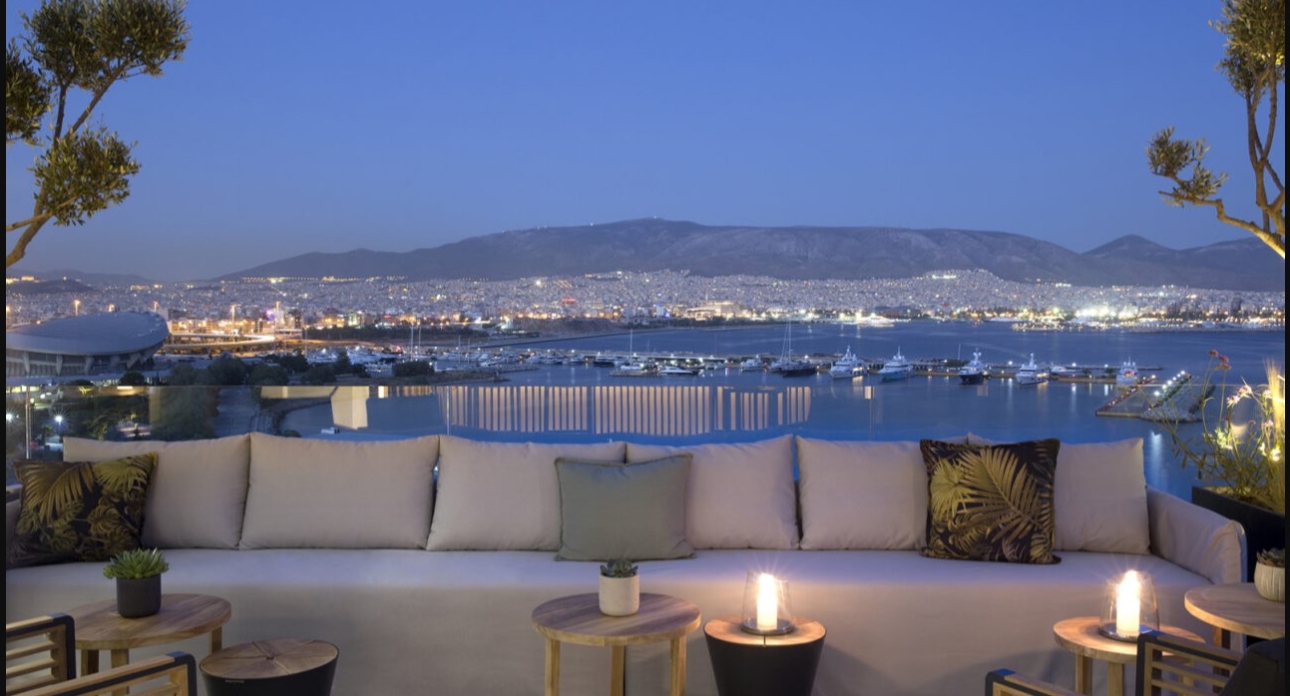 balcony shot at night with town in background and sofa in foreground