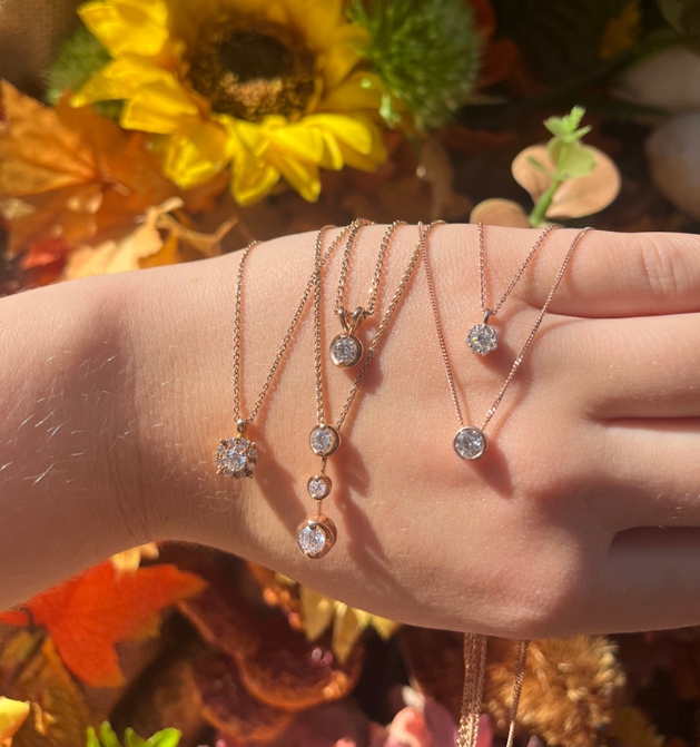 autumnal background Bradley's rose gold necklaces collection draped over a hand