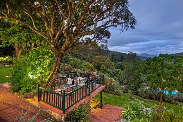 people at tables on a veranda with views of Africa