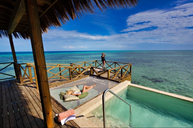 person on lounger next to private pool overlook ocean