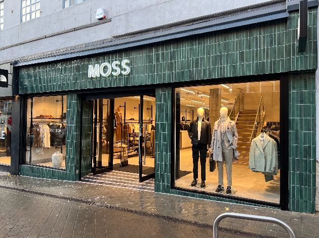 The exterior of a green and white tiled Moss store