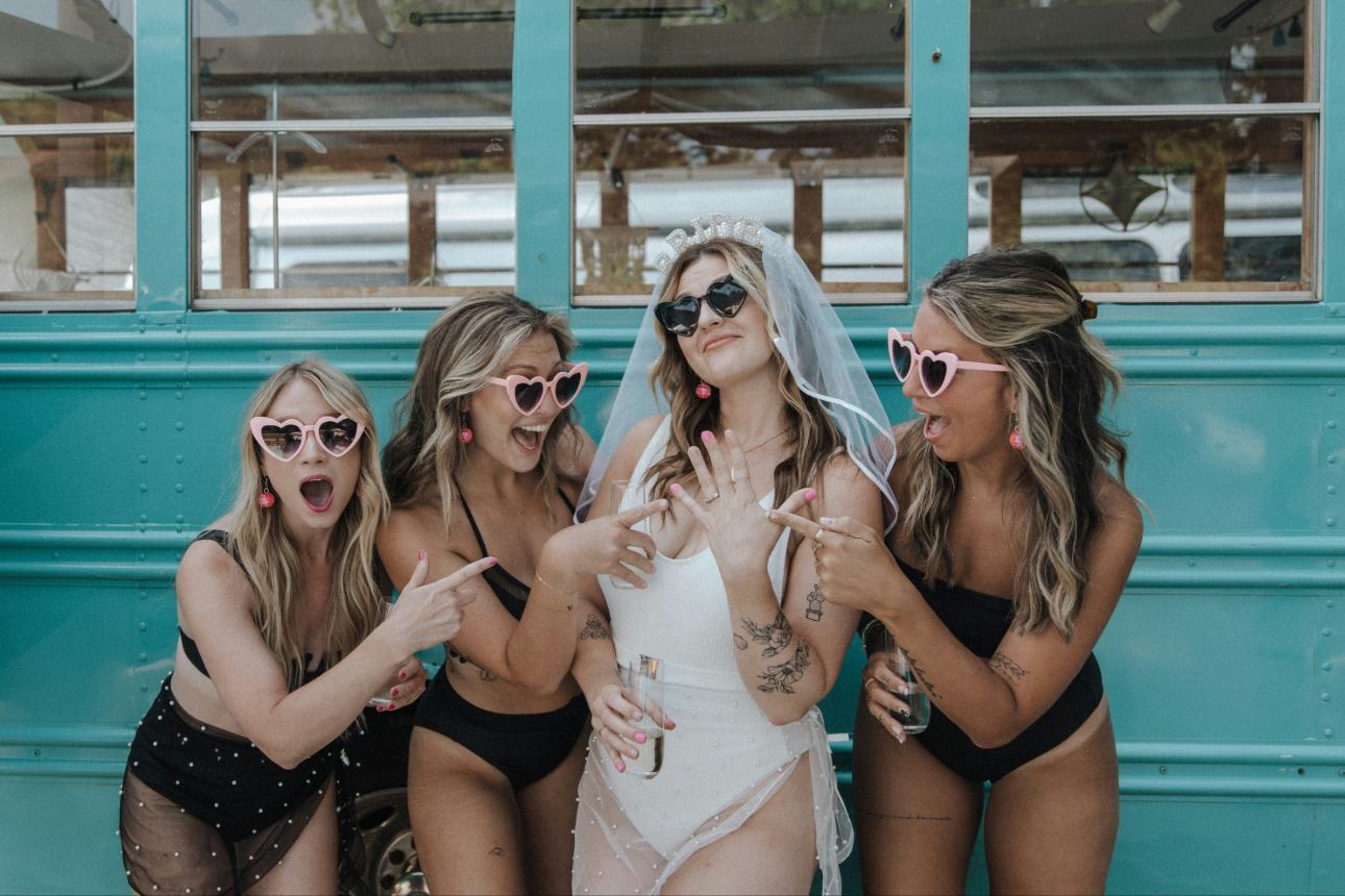 hen do in swimwear in front of a blue bus
