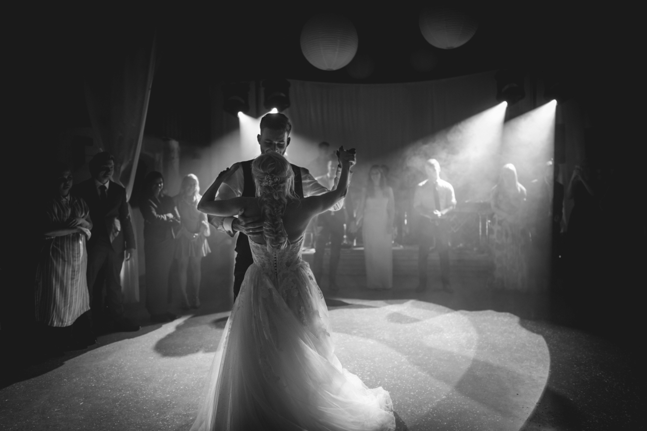 black and white photo of a couple dancing on their wedding day 