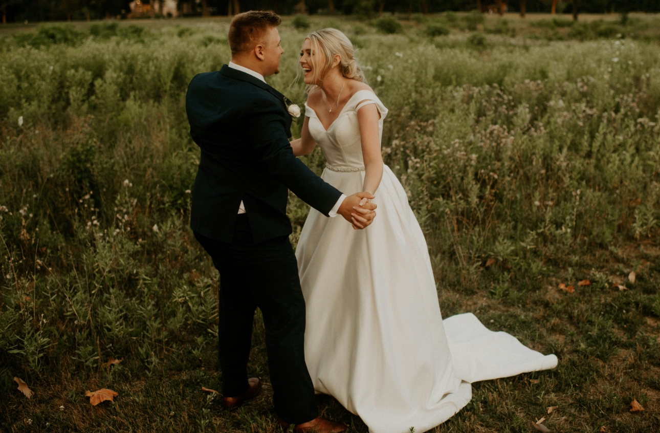wedding couple after wedding holding hands in field